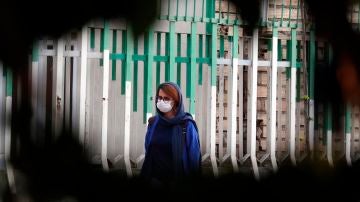 Una mujer pasea por las calles de Teherán con mascarilla