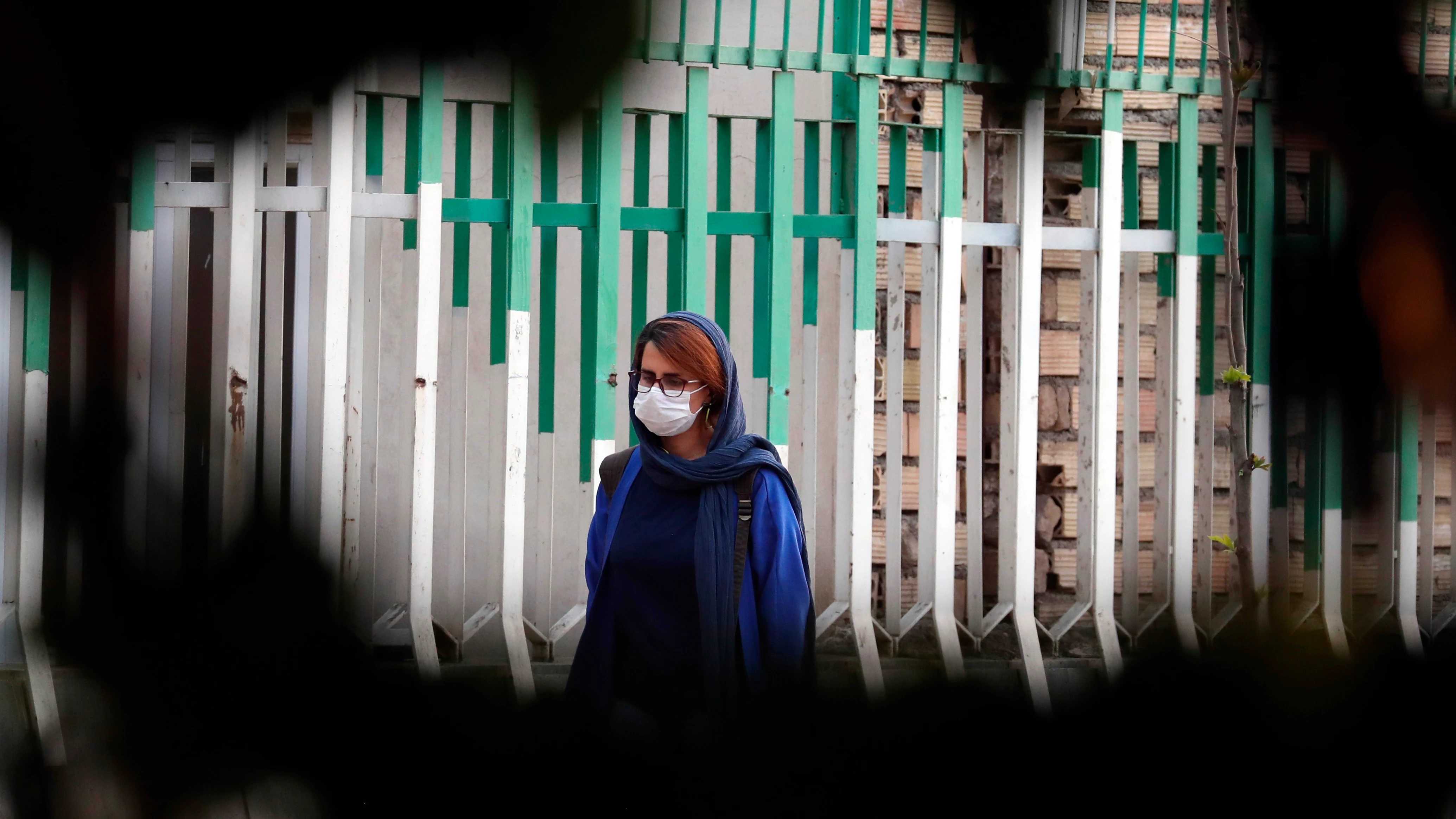 Una mujer pasea por las calles de Teherán con mascarilla