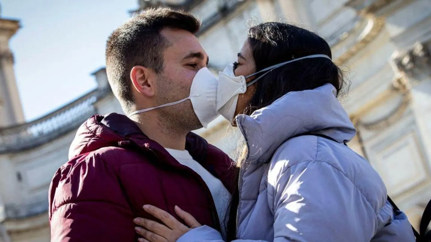 Dos jóvenes besándose con mascarilla Dos jóvenes besándose con mascarilla