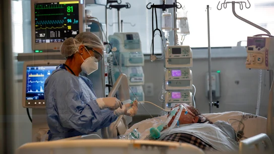 Una sanitaria suministra medicamentos a un paciente enfermo Una sanitaria suministra medicamentos a un paciente enfermo