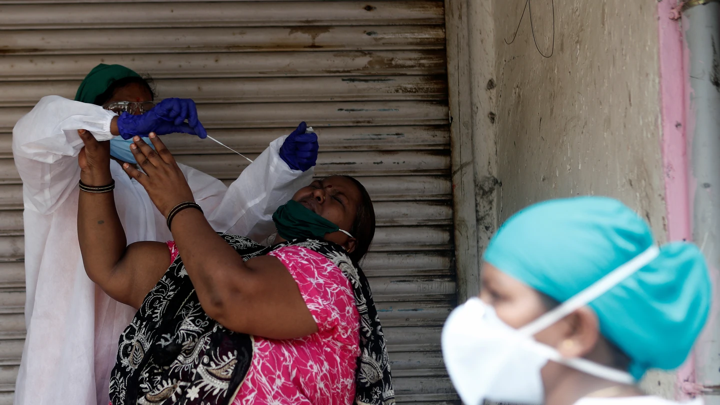 Un sanitario intenta hacer una PCR a una paciente en Mumbai Un sanitario intenta hacer una PCR a una paciente en Mumbai