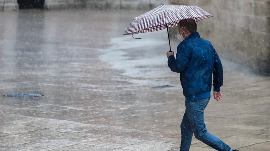 Una persona se protege de la lluvia con paraguas en el centro de Valencia Una persona se protege de la lluvia con paraguas en el centro de Valencia