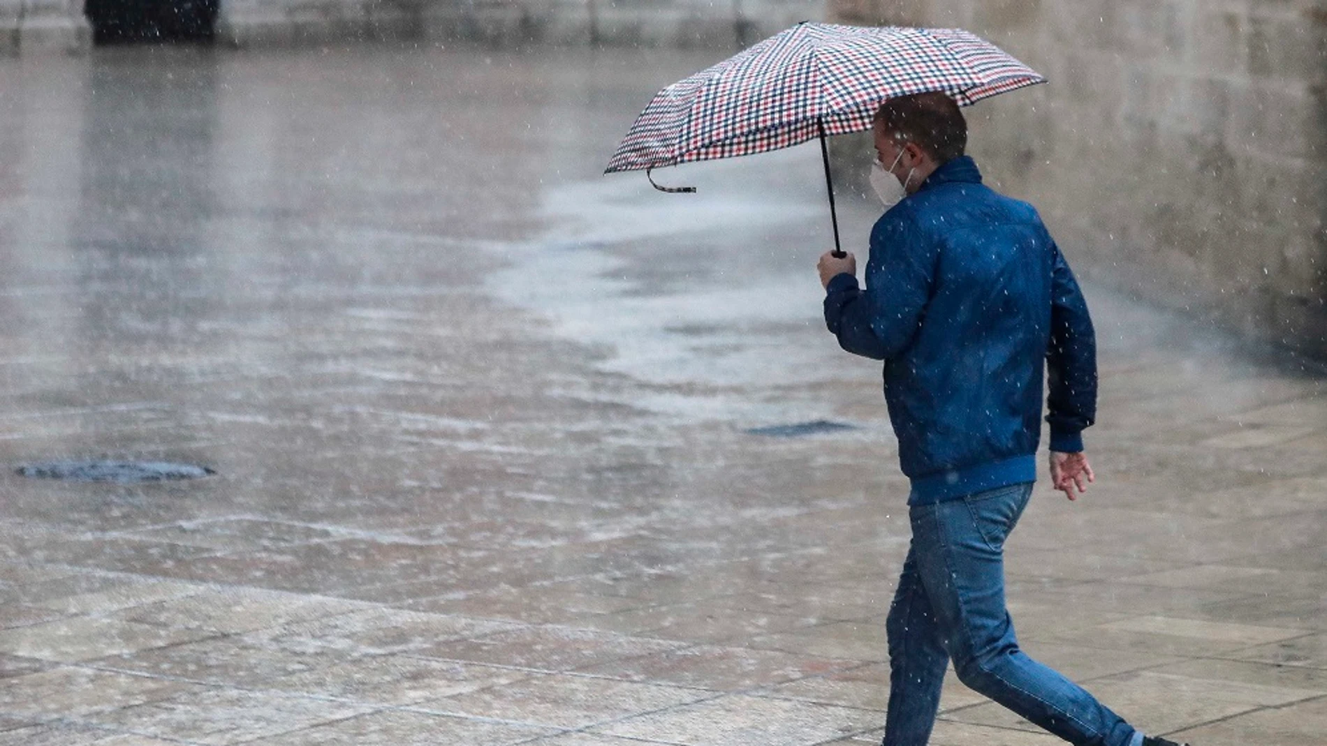 Una persona se protege de la lluvia con paraguas en el centro de Valencia