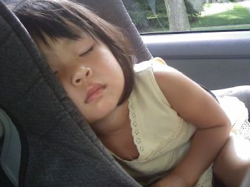 Niña dormida en el coche