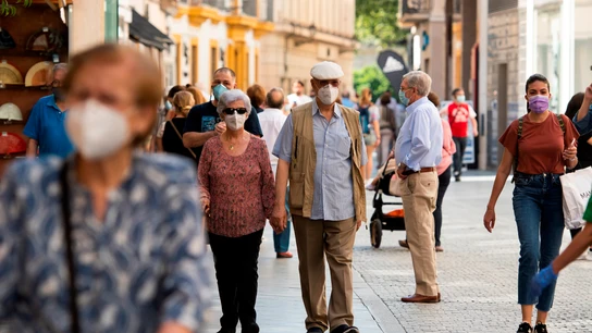 Gente caminando por la calle con mascarilla Gente caminando por la calle con mascarilla