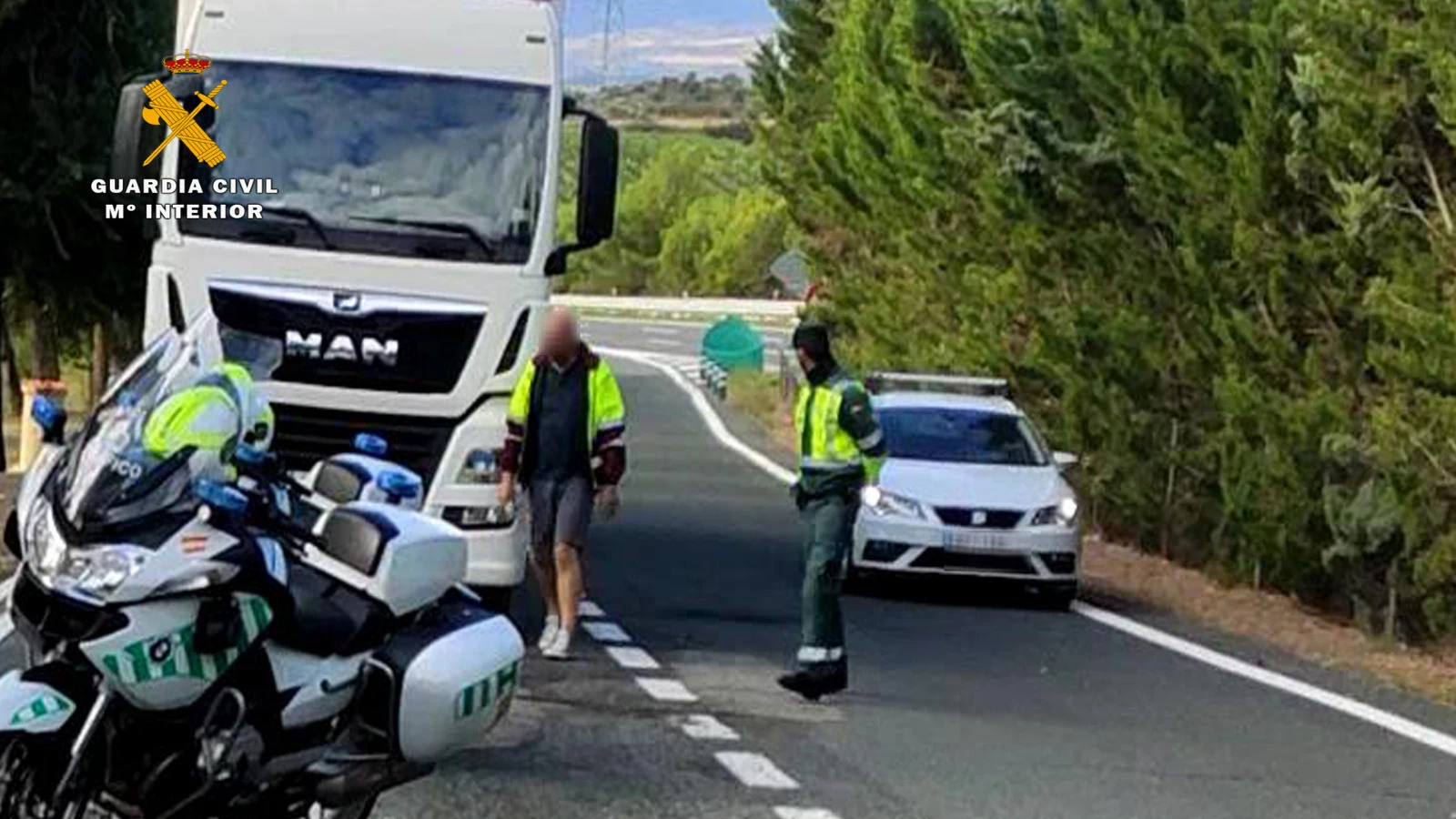 El camionero junto a un agente de la Guardia Civil