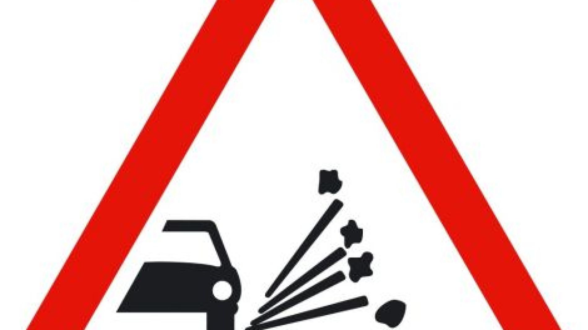 Se&ntilde;al de peligro de gravilla en la calzada.