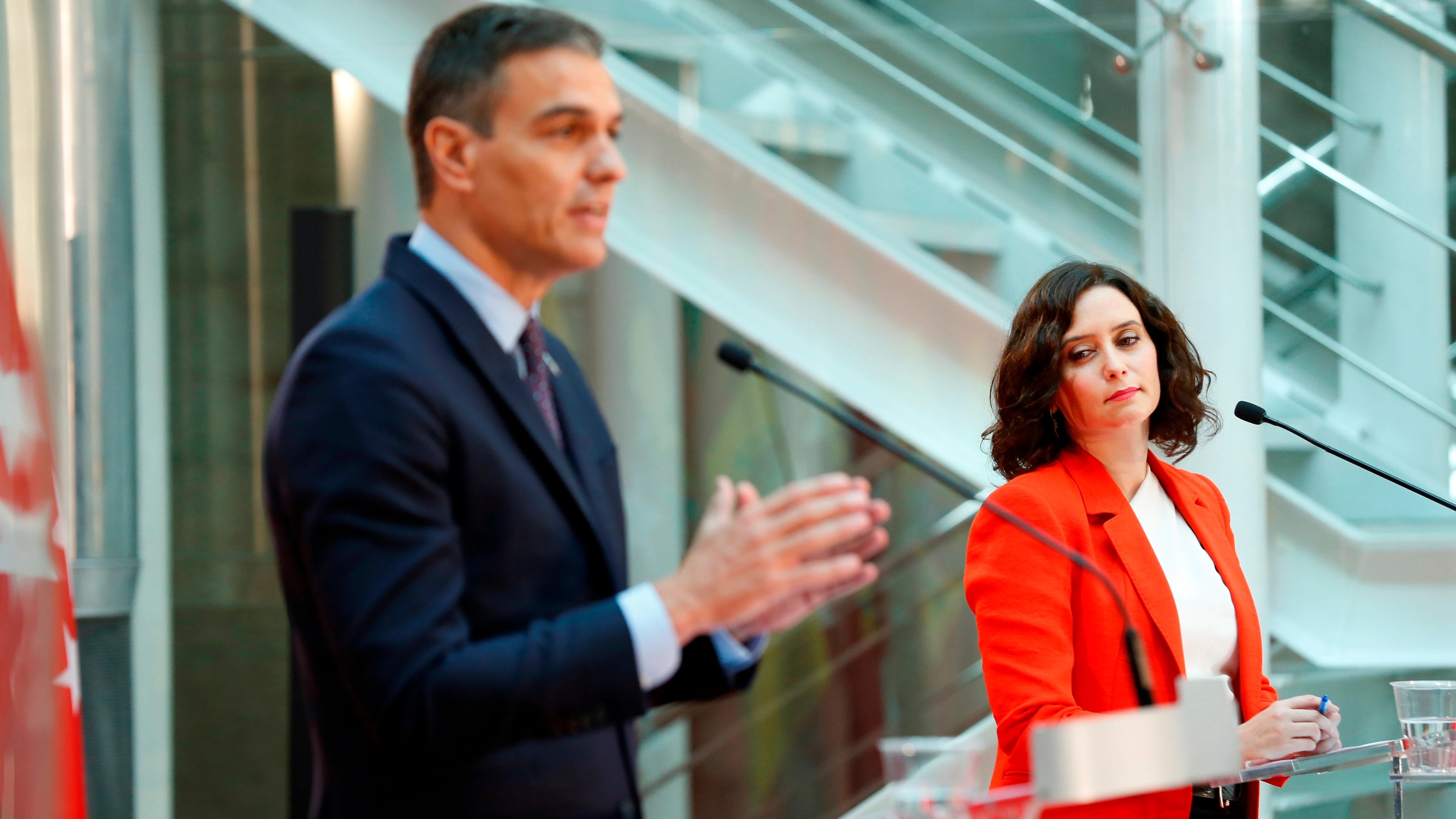 Isabel Díaz Ayuso mira a Pedro Sánchez durante su comparecencia conjunta en la Puerta del Sol