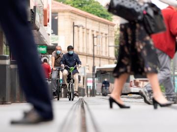 Dos personas circulan en bicicleta por una calle de Vitoria.