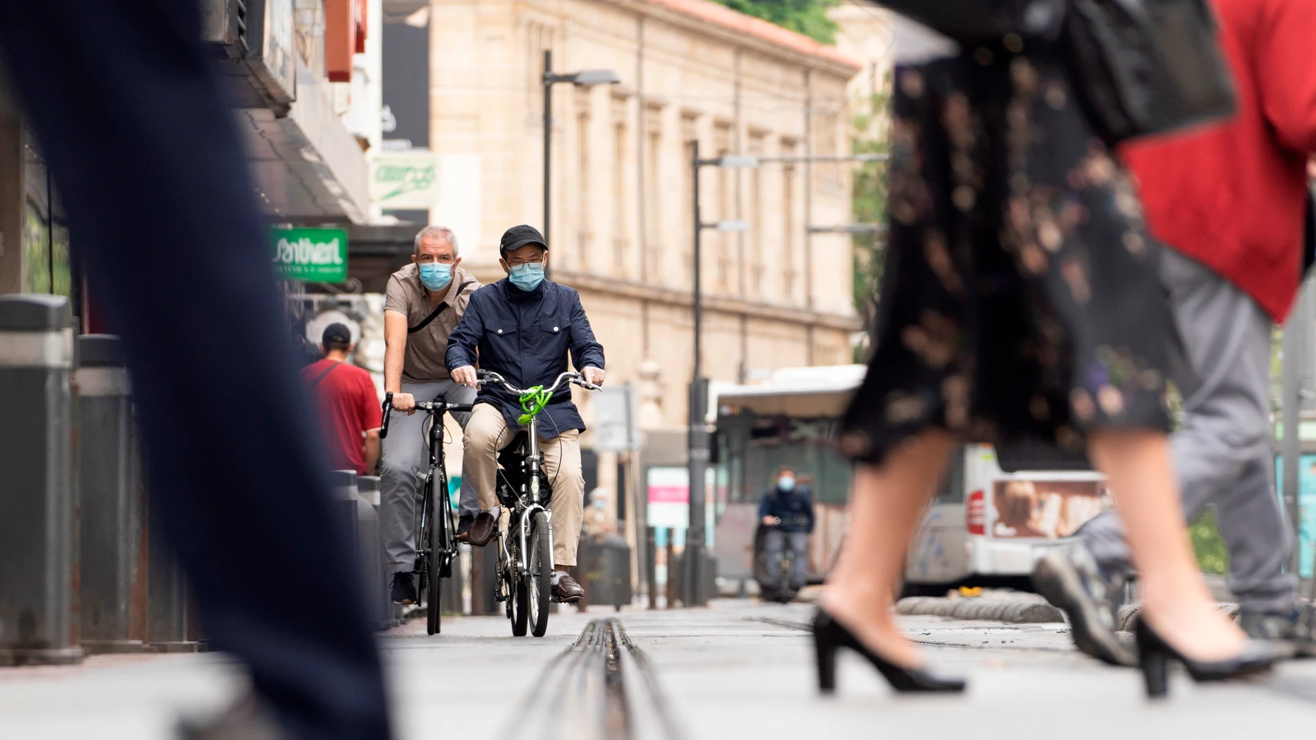 Dos personas circulan en bicicleta por una calle de Vitoria.