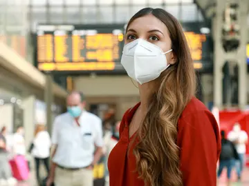 mujer con mascarilla en una estación mujer con mascarilla en una estación