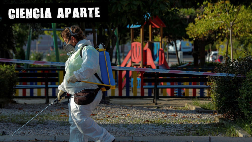 Una trabajadora municipal desinfecta las proximidades un parque infantil clausurado en la localidad madrileña de Alcobendas, Madrid