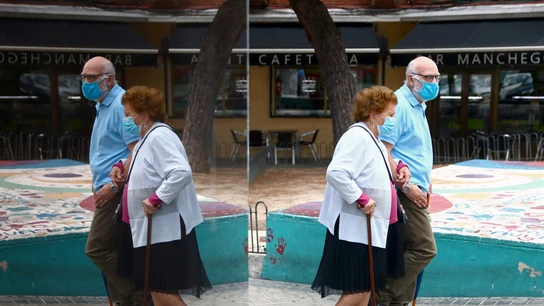 Una pareja pasea con mascarillas Una pareja pasea con mascarillas