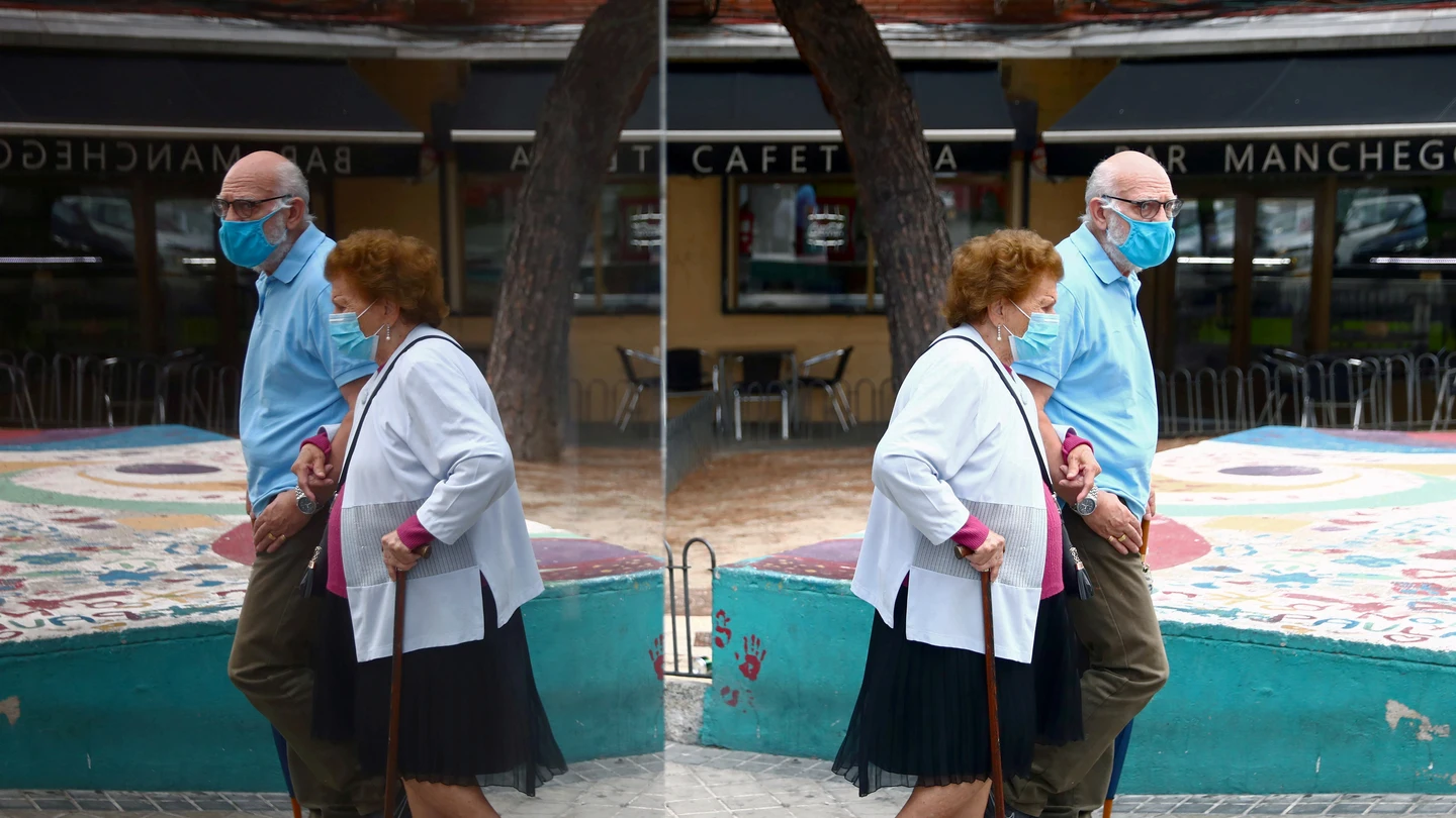 Una pareja pasea con mascarillas Una pareja pasea con mascarillas