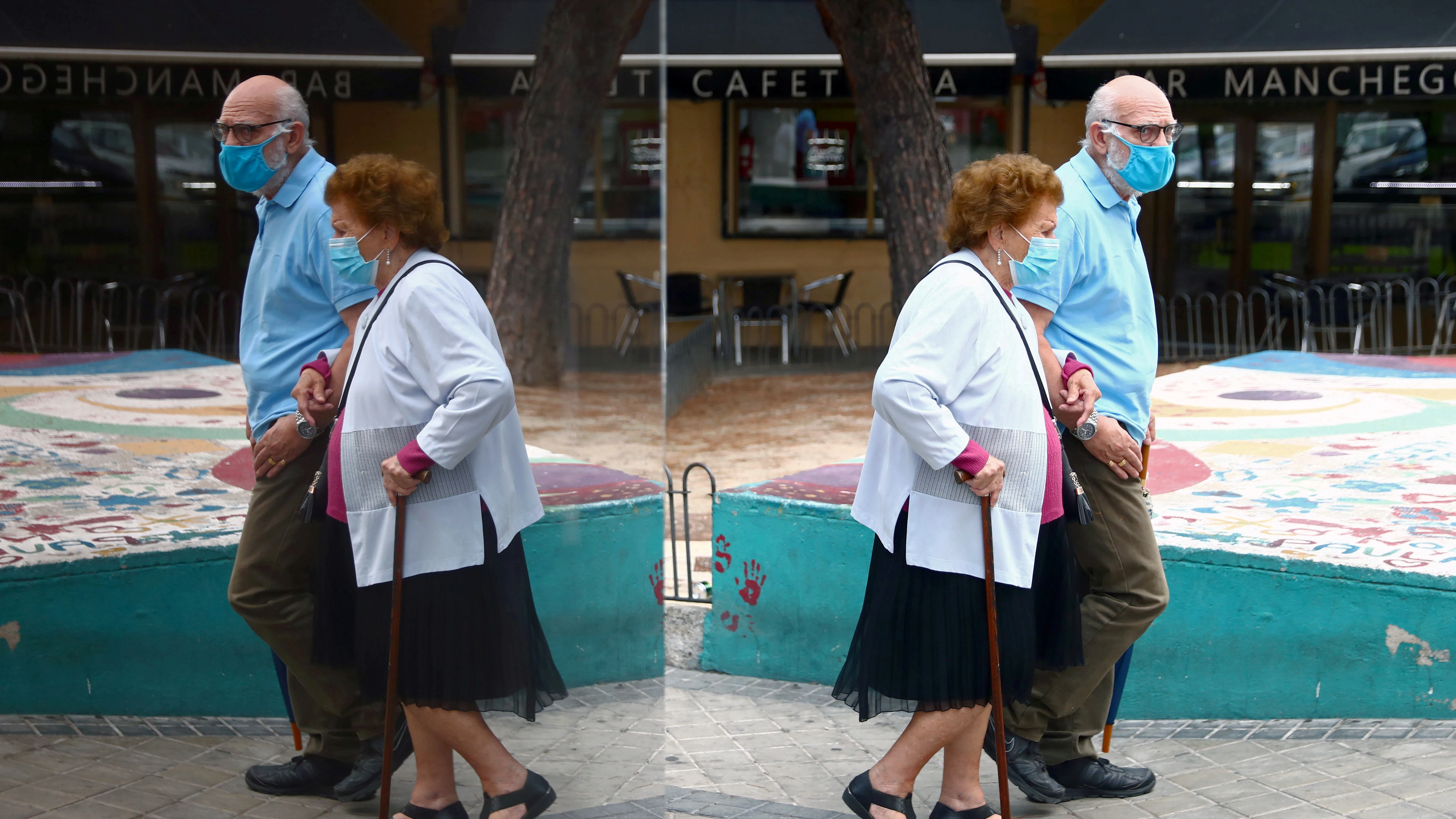 Una pareja pasea con mascarillas