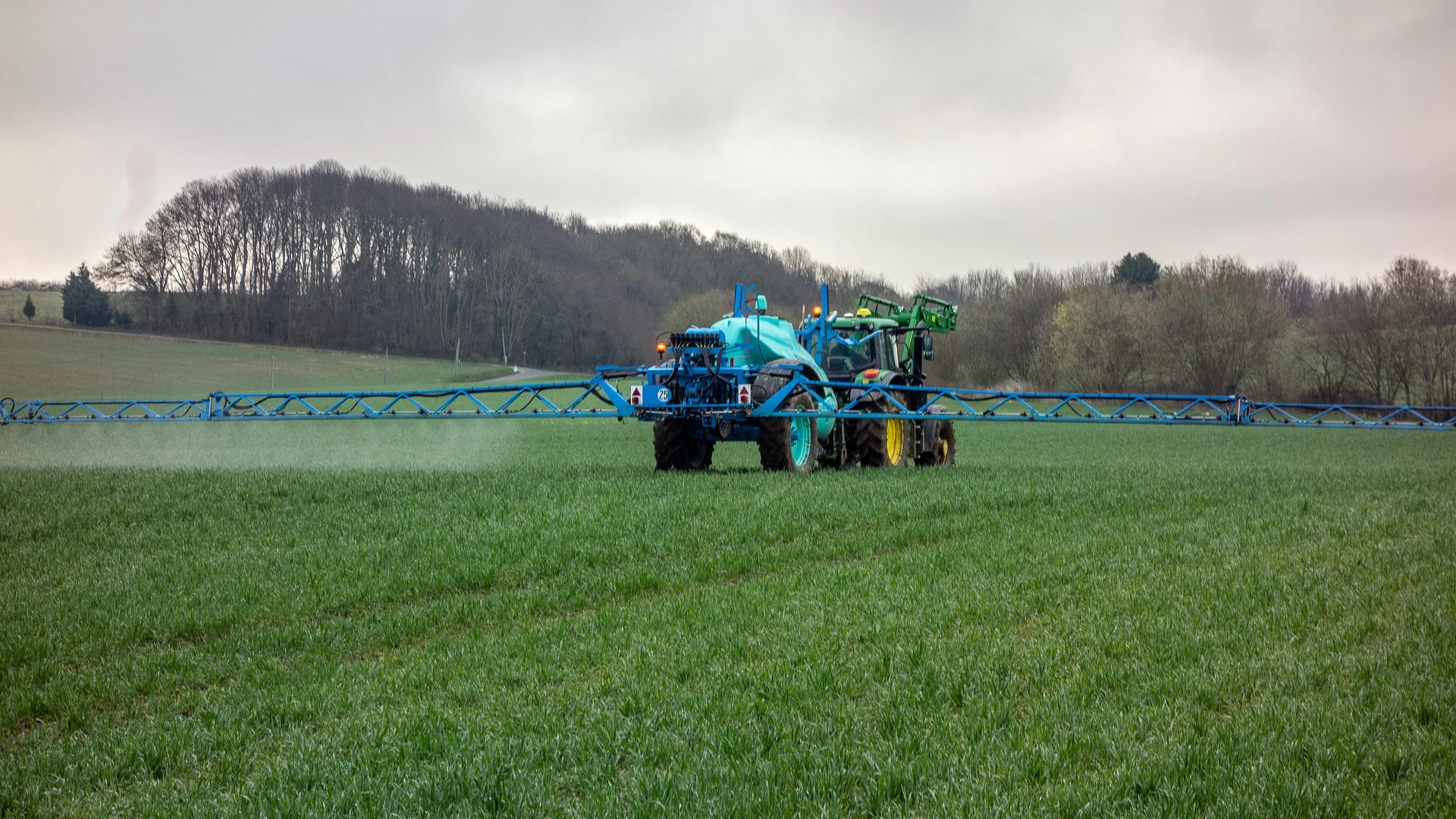 Un tractor realiza trabajos de fumigación en el campo.