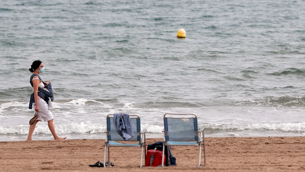 Imagen de una mujer paseando por la playa de la Malvarrosa Imagen de una mujer paseando por la playa de la Malvarrosa