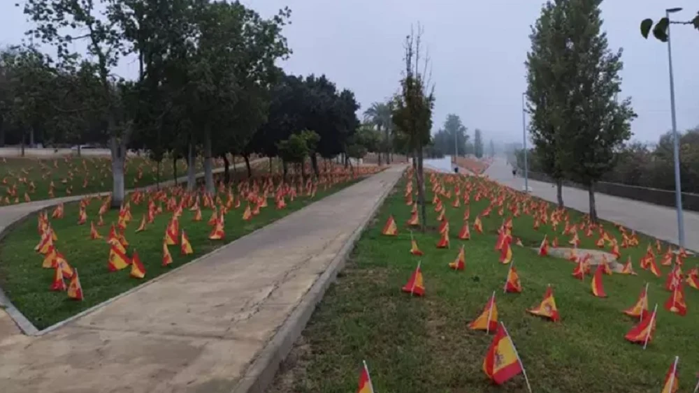 Imagen de las banderas colocadas junto al Guadalquivir en homenaje por las víctimas de coronavirus