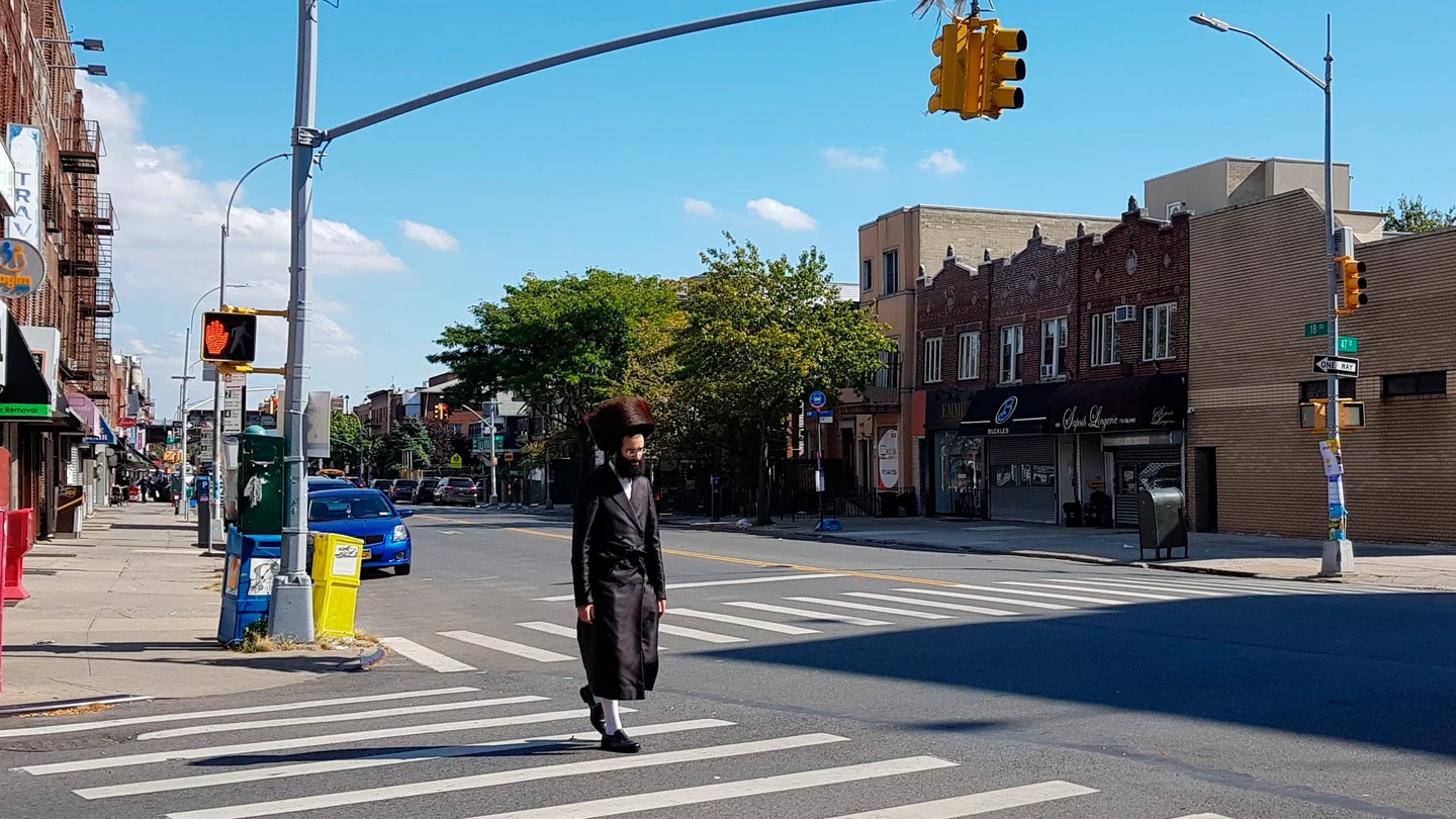 Un judío ultraortodoxo cruza una calle, sin llevar mascarilla, en el condado de Brooklyn Un judío ultraortodoxo cruza una calle, sin llevar mascarilla, en el condado de Brooklyn