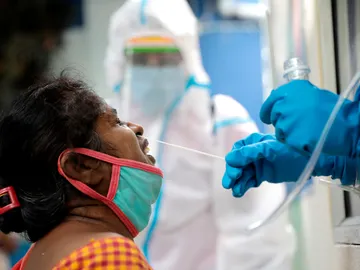 Un sanitario recoge una muestra durante una prueba rápida de COVID-19 en un centro de pruebas de Kolkata, India Un sanitario recoge una muestra durante una prueba rápida de COVID-19 en un centro de pruebas de Kolkata, India