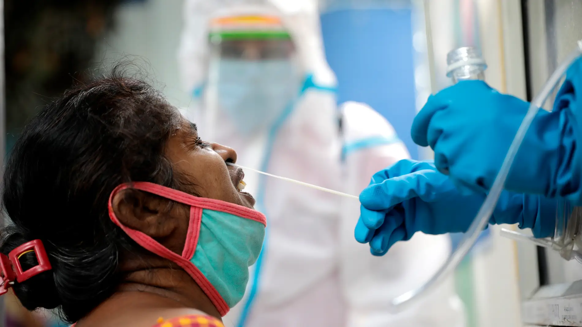 Un sanitario recoge una muestra durante una prueba rápida de COVID-19 en un centro de pruebas de Kolkata, India