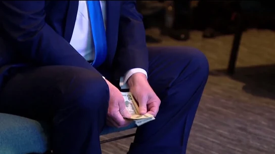 Donald Trump contando varios billetes antes de hacer una donación Donald Trump contando varios billetes antes de hacer una donación