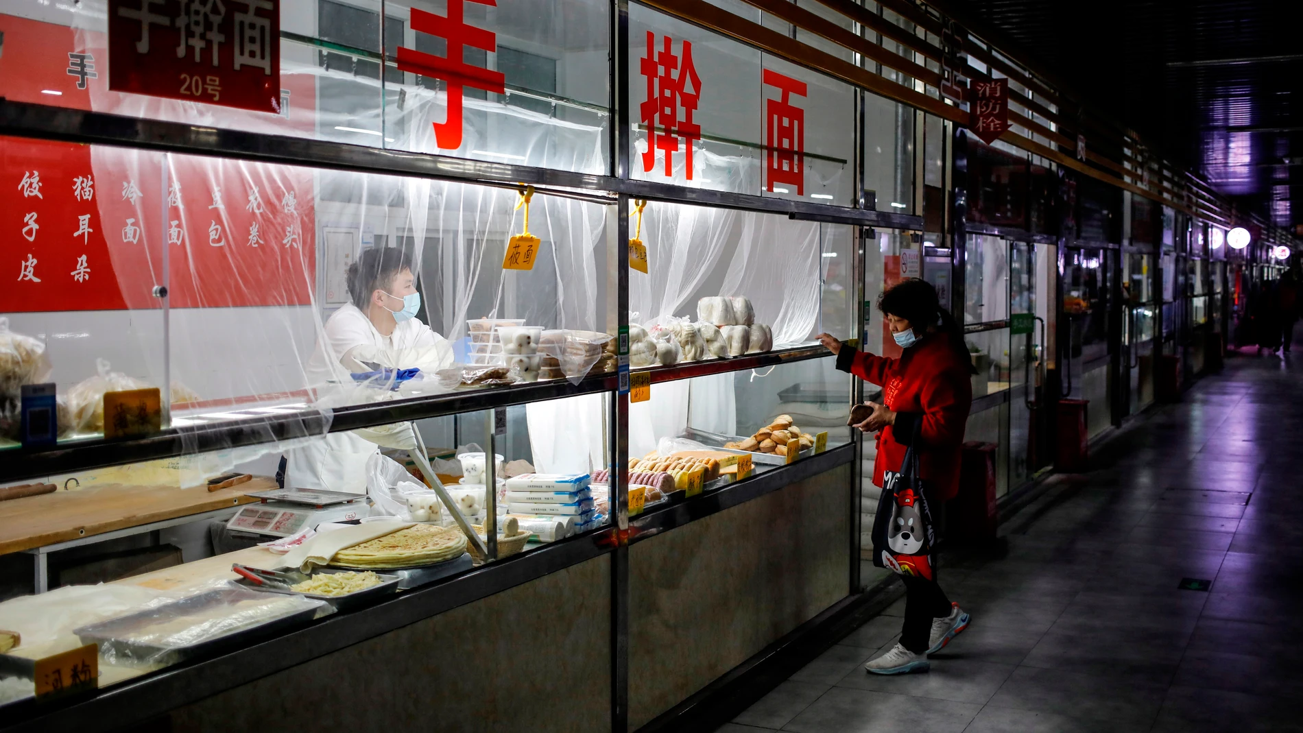 Una mujer compra en un mercado de Pekín
