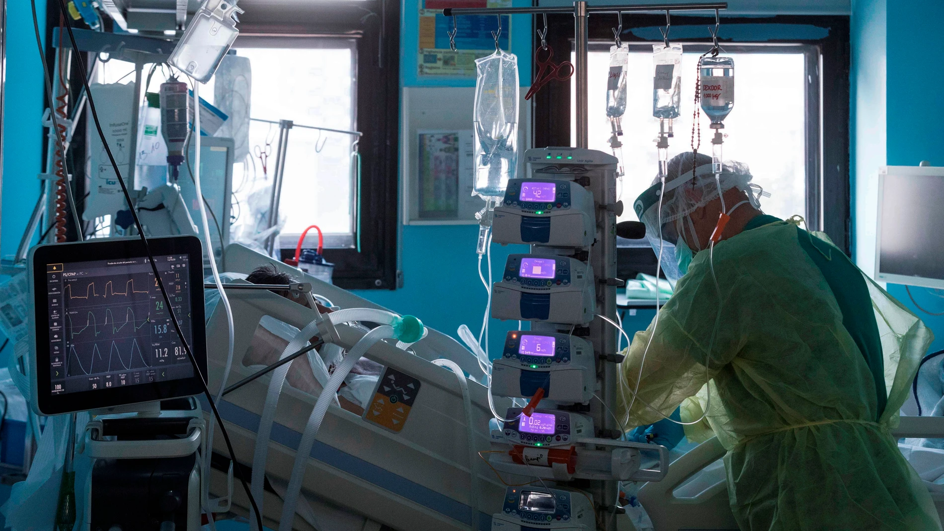 Un enfermero del centro hospitalario atiende a un paciente ingresado por COVID-19 en la UCI