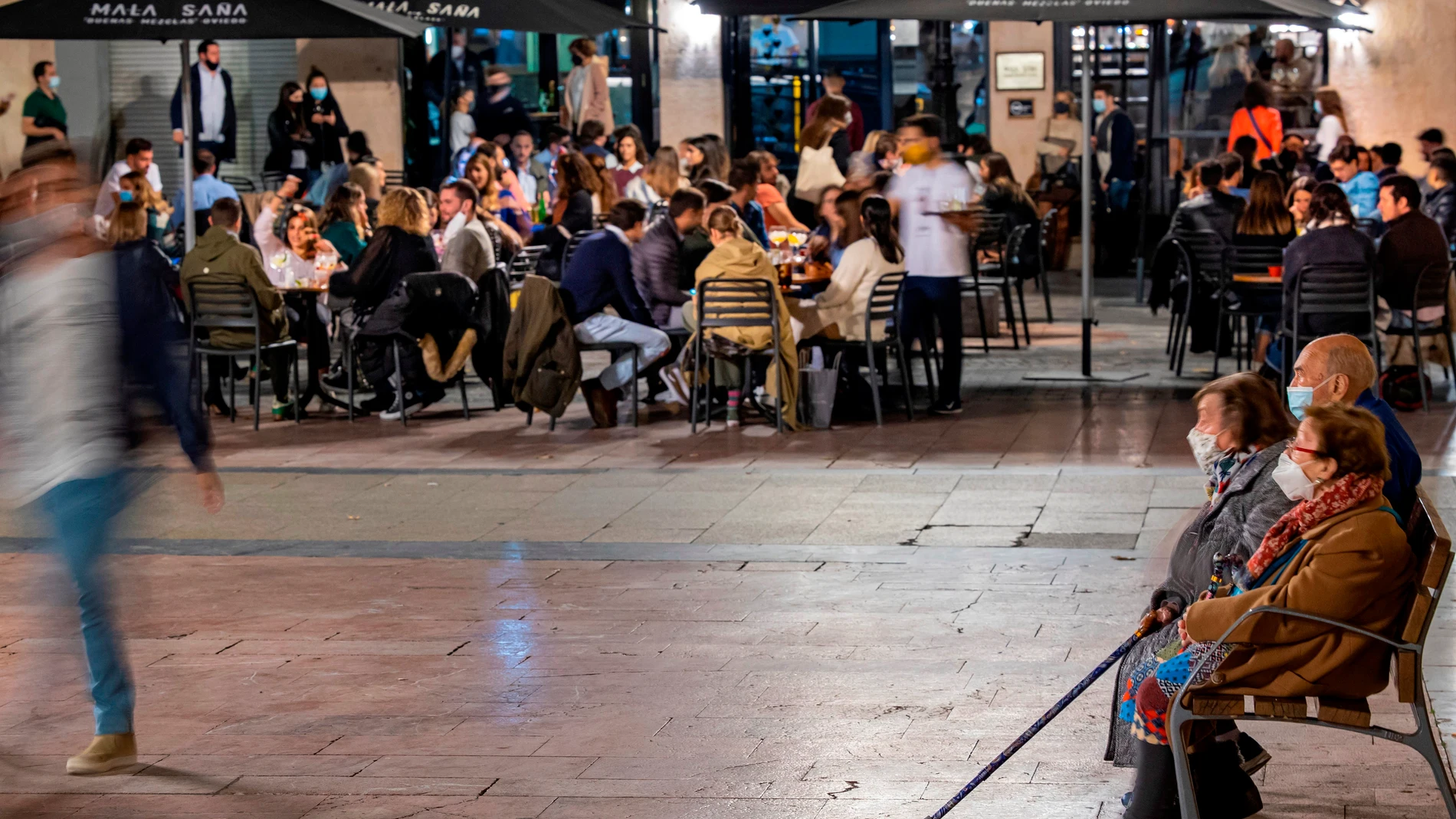 Imagen de una plaza del centro de Oviedo con una cafetería llena de clientes 