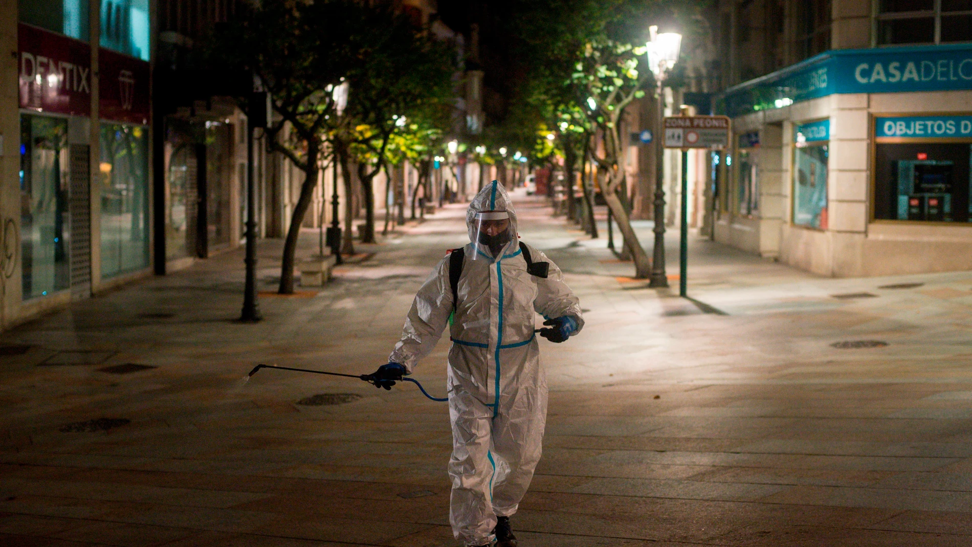 un operario municipal realiza labores de desinfección, en la calle del Paseo de Ourense