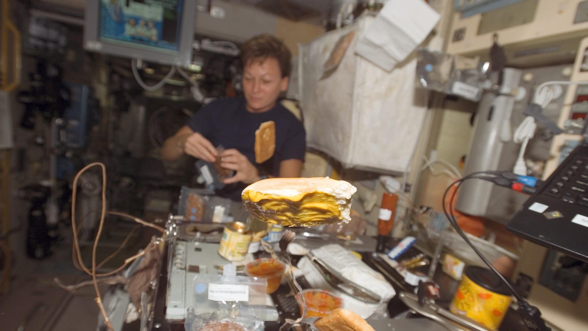 Astronauta preparando una comida.