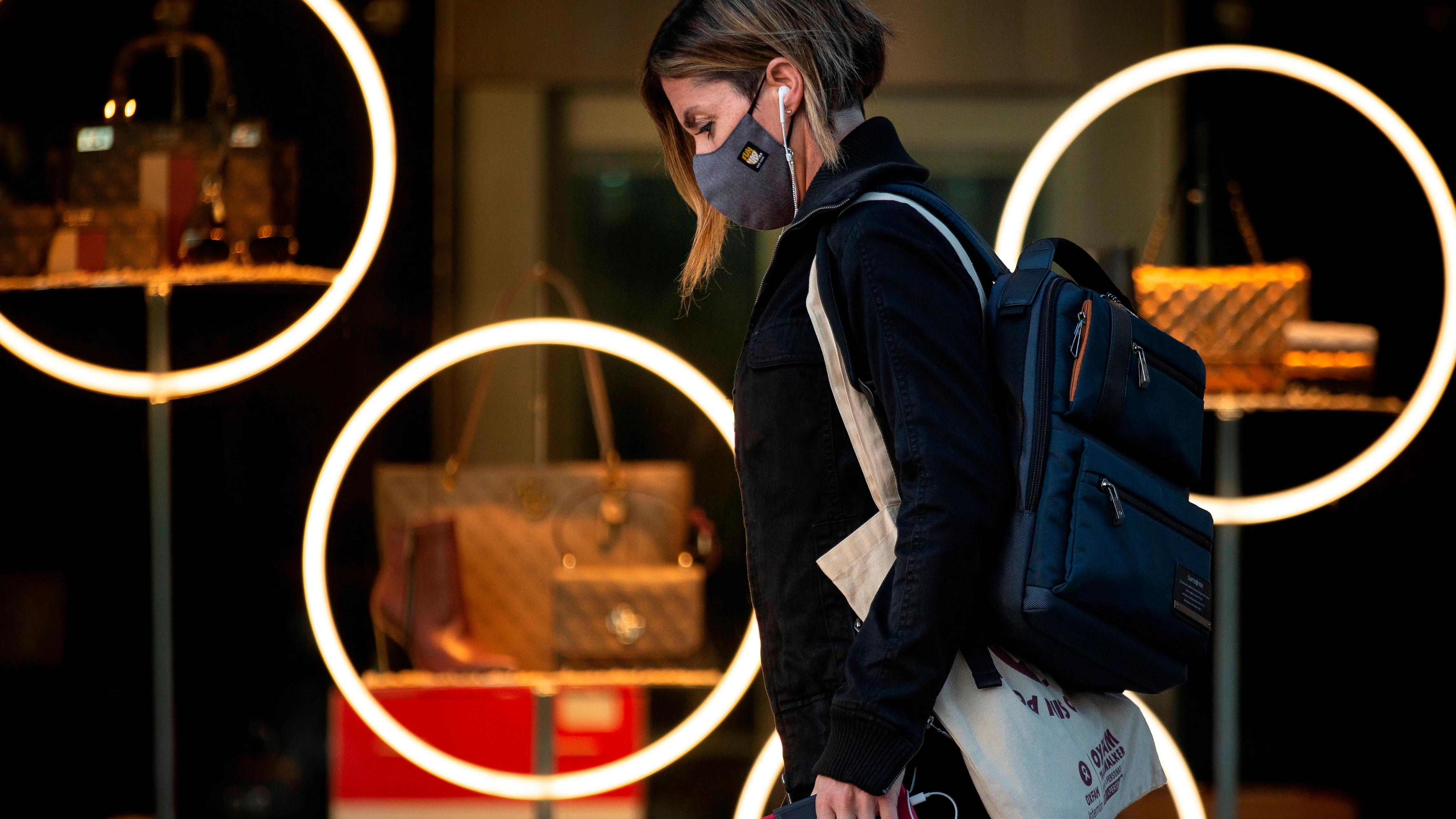 Una mujer con mascarilla pasea por Paseo de Gracia, en Barcelona