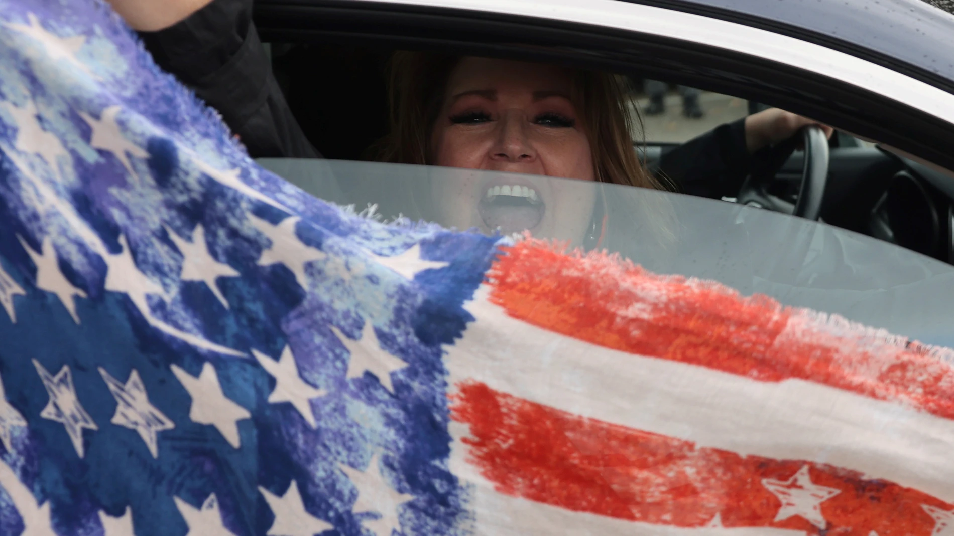 Una seguidora de Trump enarbola la bandera estadounidense desde el coche en Oregon