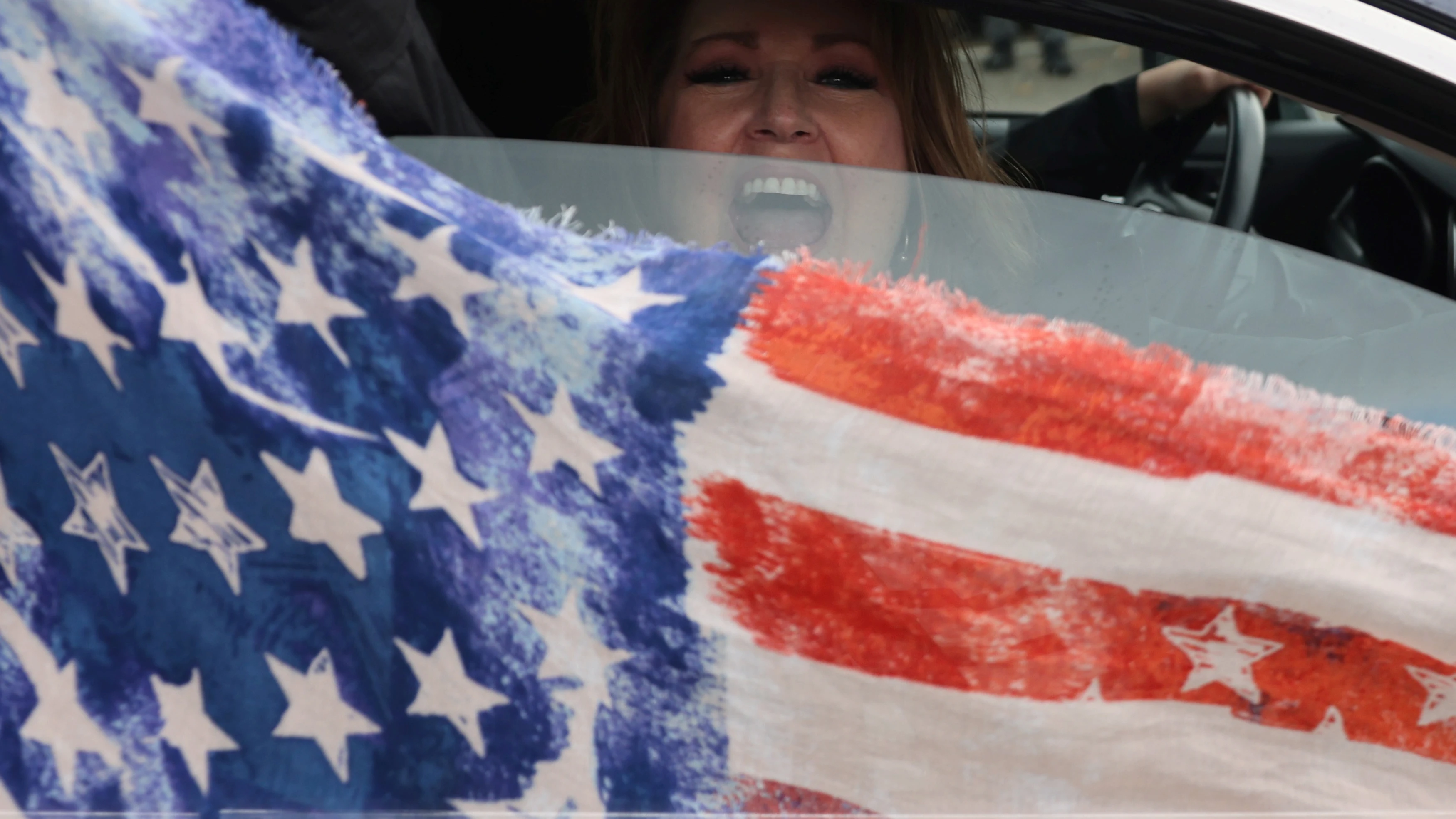 Una seguidora de Trump enarbola la bandera estadounidense desde el coche en Oregon