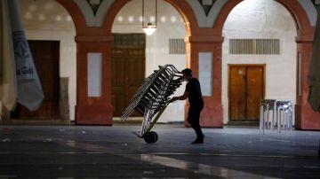 Un camarero recoge la terraza de su bar en Córdoba