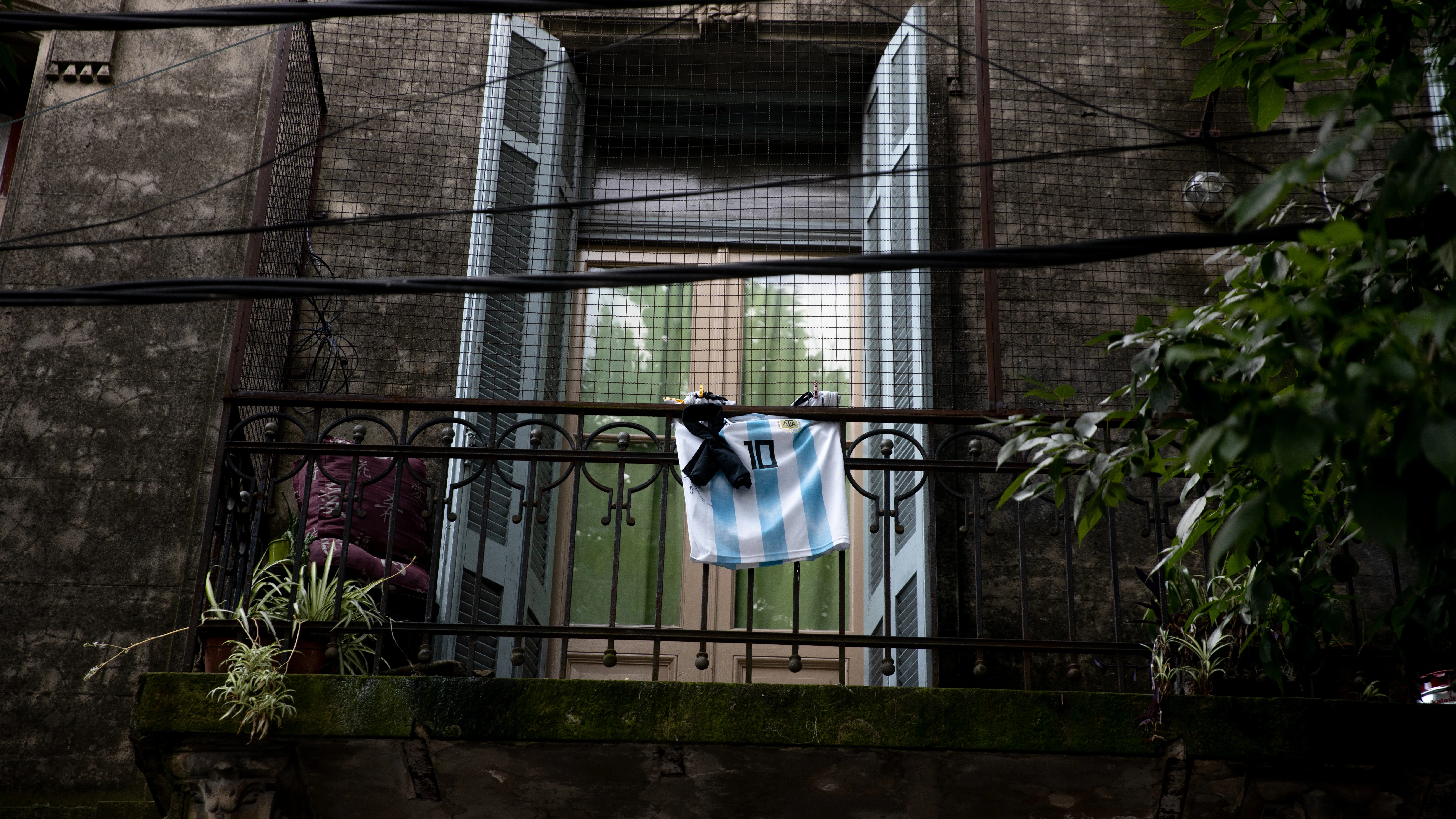 Un balcón con una camiseta de Maradona y un crespón negro