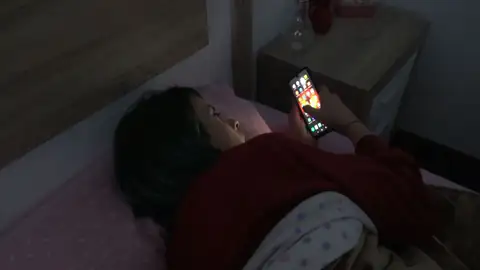 Chica usando el móvil en cama Chica usando el móvil en cama