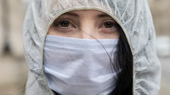 Una mujer con mascarilla mira a cámara Una mujer con mascarilla mira a cámara