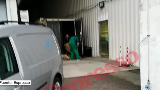 Operarios retiran un ataúd de un contenedor en el Véneto Operarios retiran un ataúd de un contenedor en el Véneto