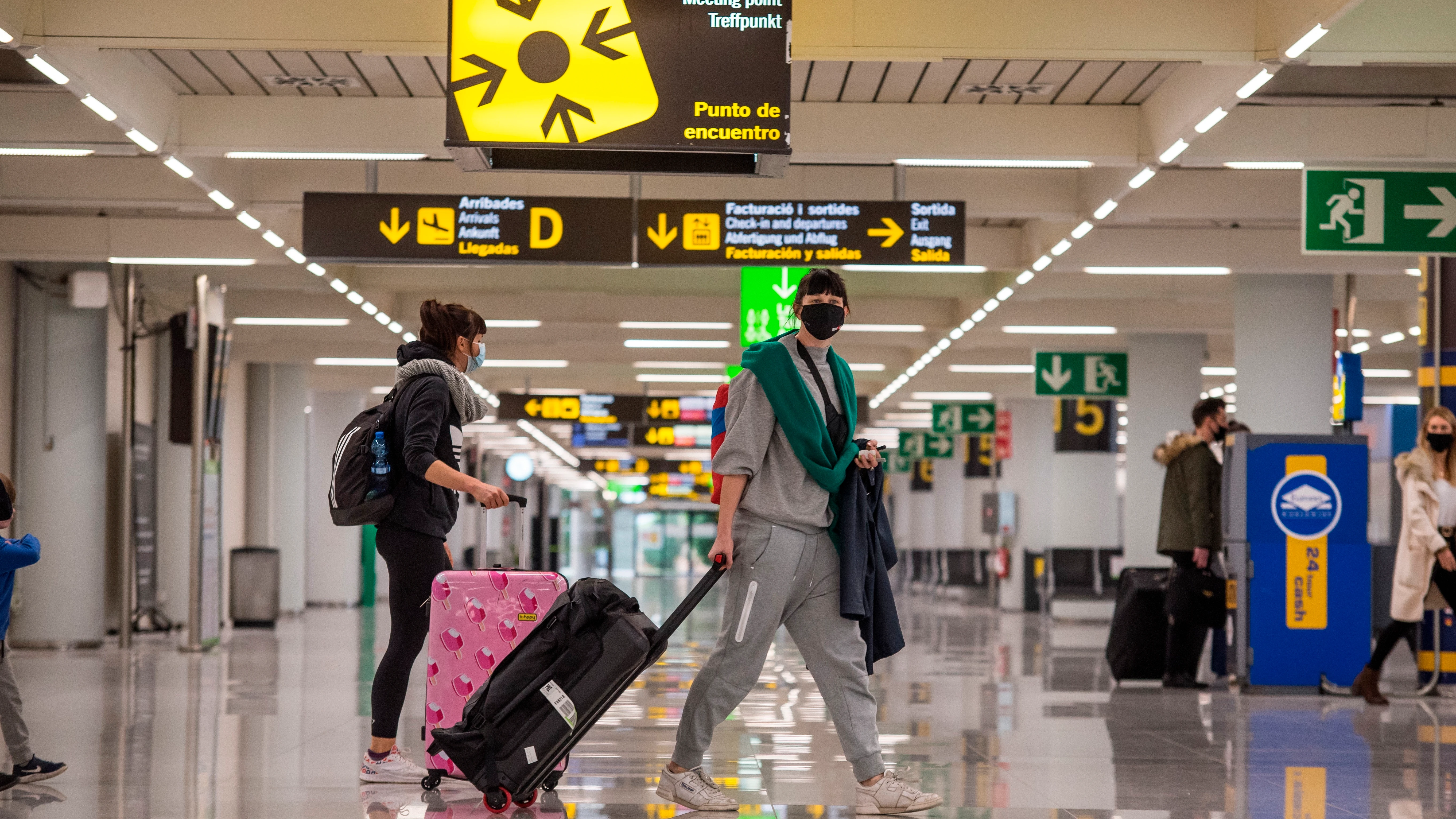 Viajeros caminan por la terminal de llegadas del aeropuerto