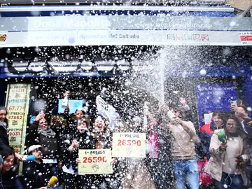 Un grupo de personas celebran en Doña Manolia el Gordo de la Lotería de Navidad 2019