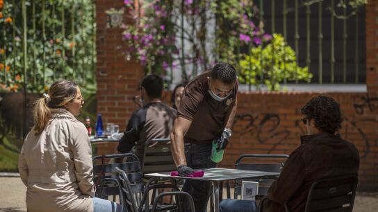 Un hostelero atiende una terraza en Sevilla