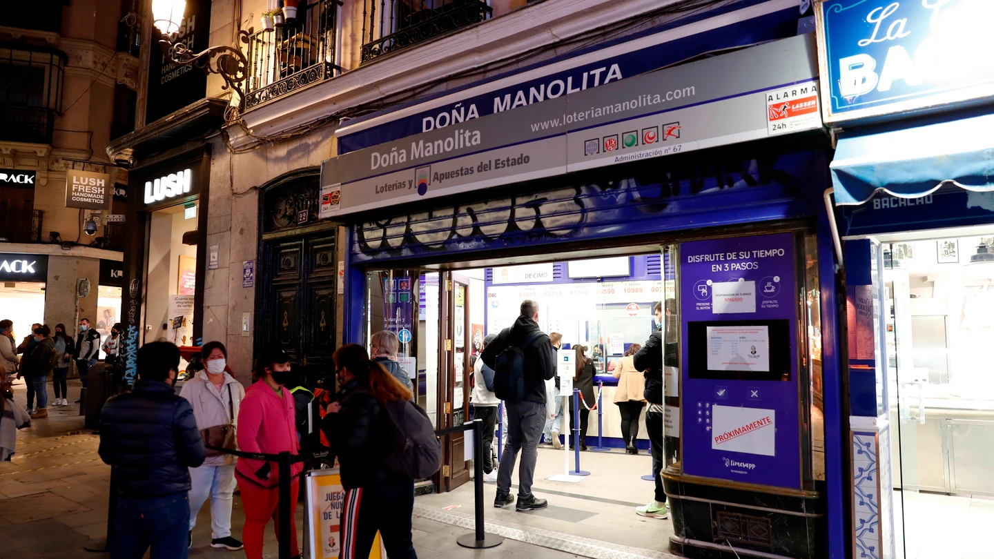 Varias personas esperan a las puertas de la administración de Lotería de Doña Manolita, en Madrid. Varias personas esperan a las puertas de la administración de Lotería de Doña Manolita, en Madrid.