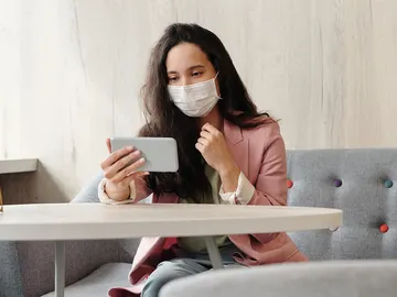 Con mascarilla y un smartphone Con mascarilla y un smartphone