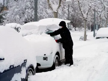 Hombre limpiando nieve de su coche Hombre limpiando nieve de su coche