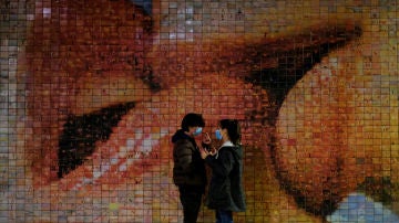 Una pareja pasea por Barcelona con mascarilla