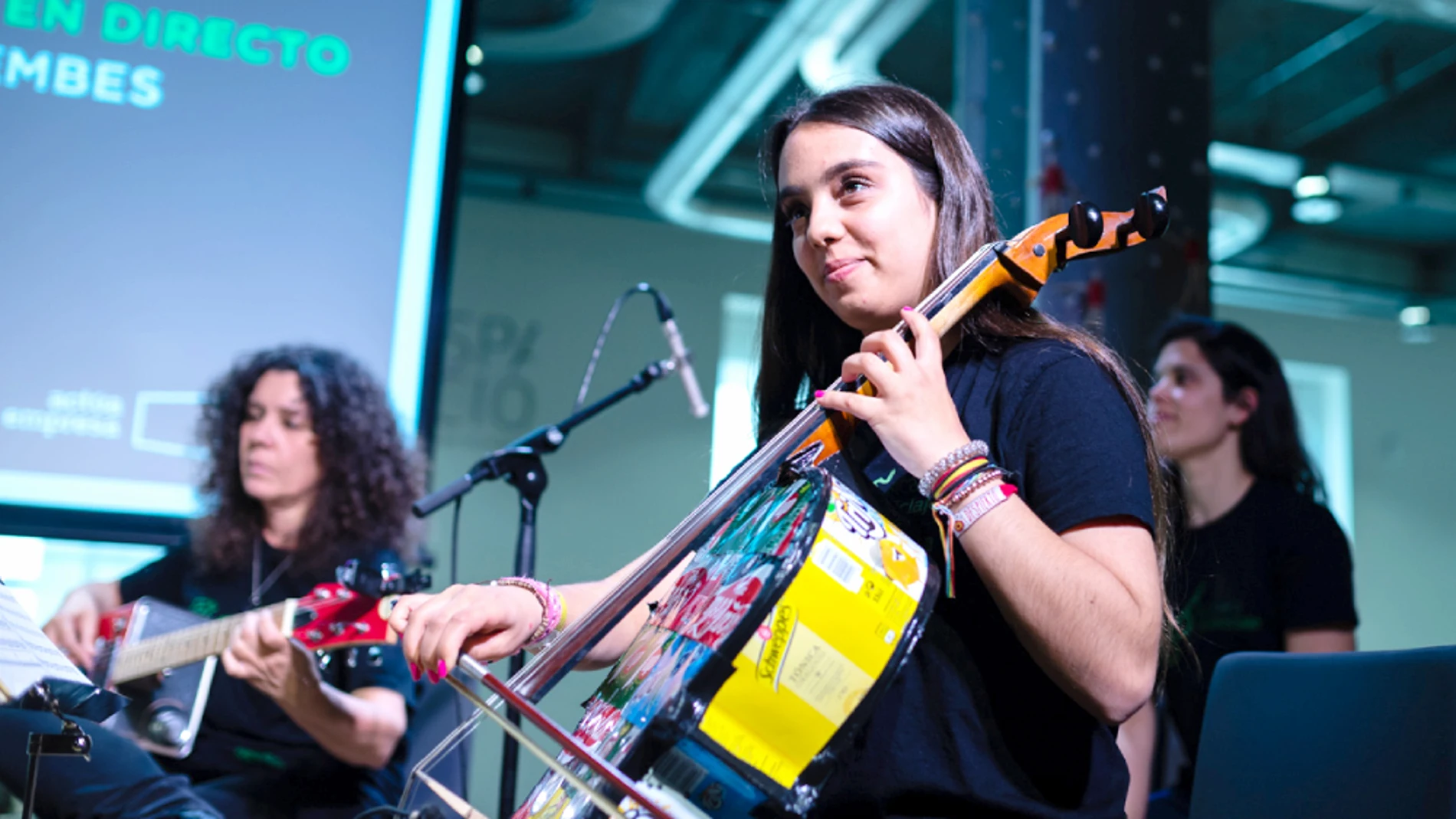 Una joven de la orquesta de 'La música del reciclaje' toca un instrumento construido con residuos