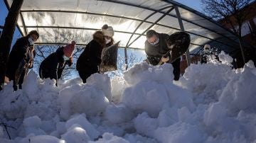 Personal de limpieza y padres recogen nieve de un colegio de Colmenar Viejo