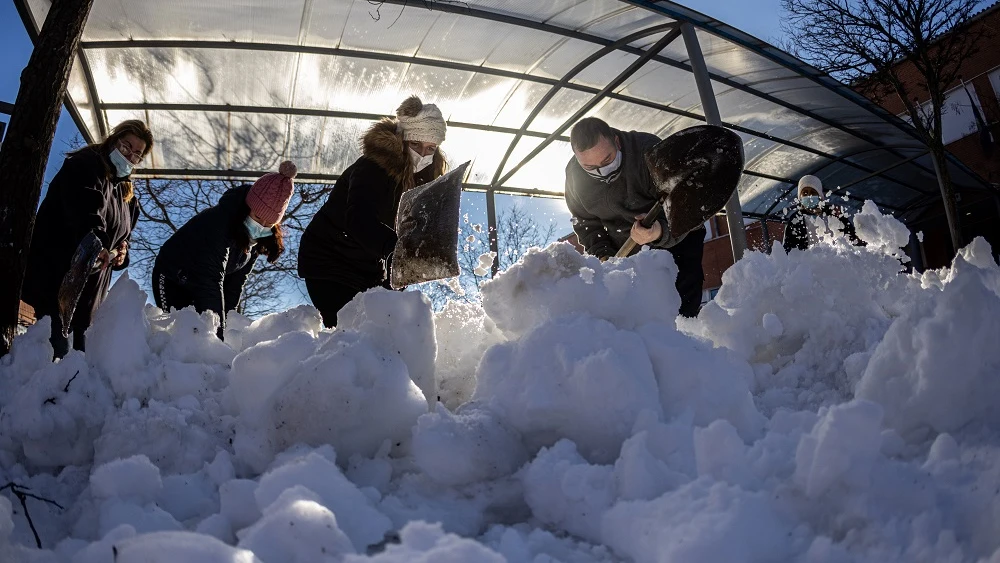 Personal de limpieza y padres recogen nieve de un colegio de Colmenar Viejo