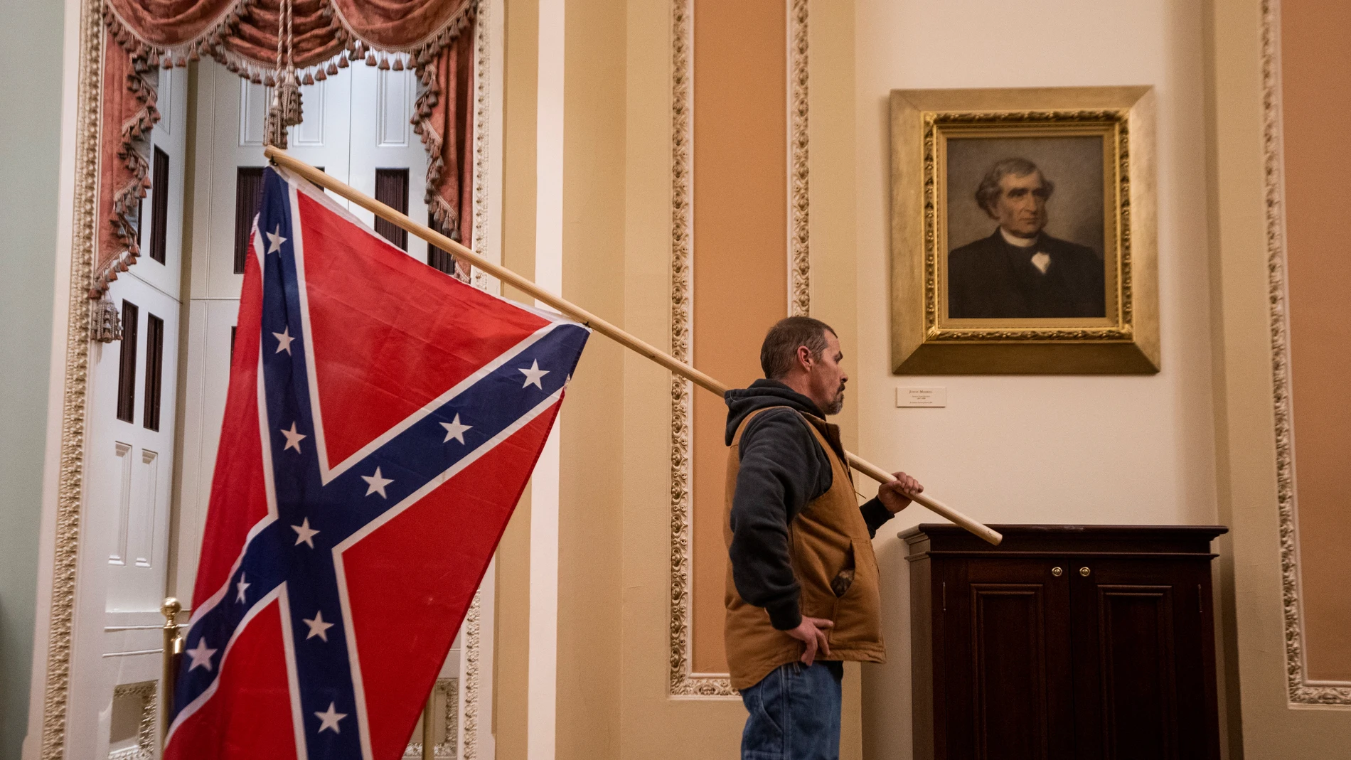 Uno de los asaltantes del Capitolio porta la bandera confederada